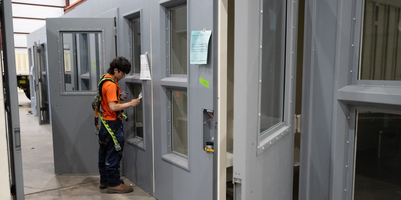 picture of a technician installing a jail cell hinge for maximum security