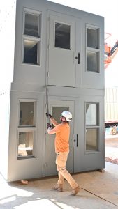 person working on modular jail cells